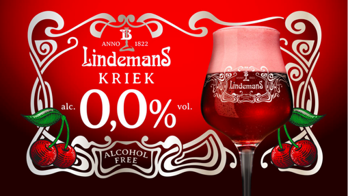 Birra Lindemans Kriek analcolica 0,0% con ciliegie fresche in un elegante bicchiere su sfondo rosso.